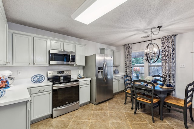 2300 Avalon Creek Way, Mckinney, TX 75071 - kitchen with appliances with stainless steel finishes, a chandelier, light countertops, a textured ceiling, and pendant lighting