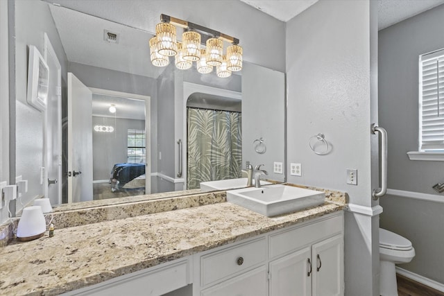 500 W San Diego St, Detroit, TX 75436 - ensuite bathroom featuring a chandelier, vanity, toilet, and baseboards