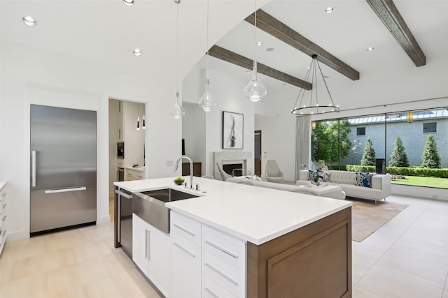 315 Oxford Pl, Coppell, TX 75019 - kitchen with stainless steel appliances, a sink, open floor plan, an island with sink, and white cabinetry