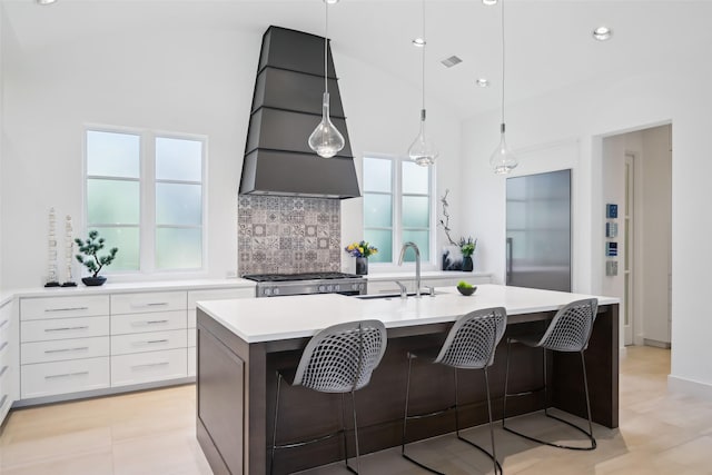 315 Oxford Pl, Coppell, TX 75019 - kitchen featuring a sink, light countertops, a center island with sink, decorative backsplash, and stove