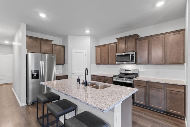 506 Cool Canyon Trl, Princeton, TX 75407 - kitchen with stainless steel appliances, a sink, dark wood-style floors, light stone counters, and recessed lighting