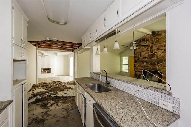 245 Straw Rd, Saginaw, TX 76179 - kitchen featuring a stone fireplace, a sink, a ceiling fan, white cabinets, and unfinished concrete floors