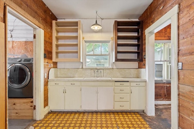 2600 Colcord Ave, Waco, TX 76707 - kitchen featuring washer / dryer, light countertops, a sink, healthy amount of natural light, and wooden walls