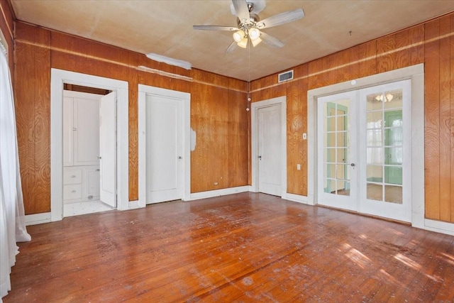 2600 Colcord Ave, Waco, TX 76707 - empty room with french doors, wooden walls, wood finished floors, and a ceiling fan