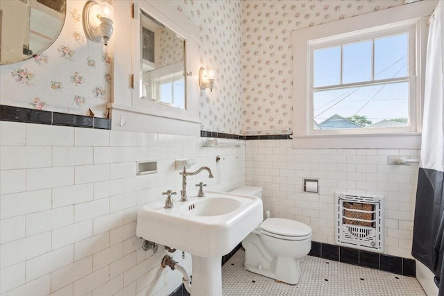 2600 Colcord Ave, Waco, TX 76707 - bathroom with heating unit, wallpapered walls, wainscoting, toilet, and tile walls