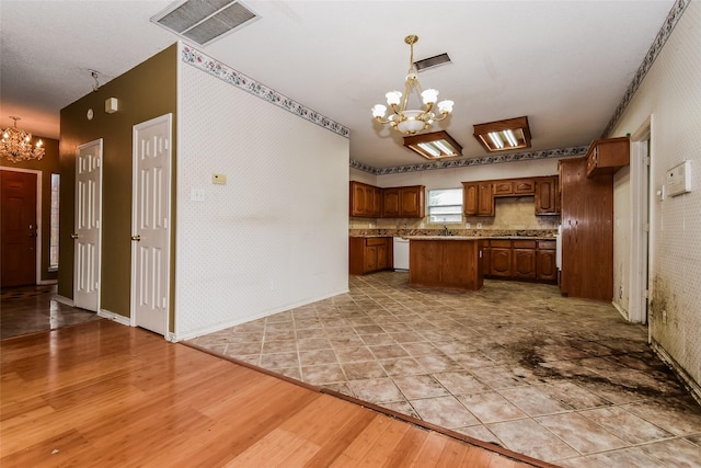 4005 Cavalier Dr, Rowlett, TX 75088 - kitchen with a chandelier, a kitchen island, wallpapered walls, white dishwasher, and wood finished floors