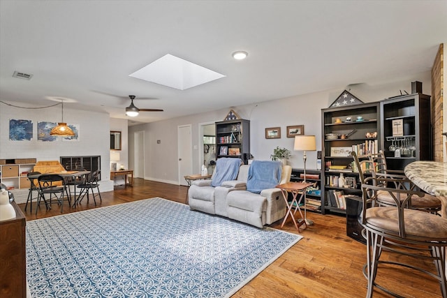 2816 Nottingham Dr, Denton, TX 76209 - living room featuring a skylight, a ceiling fan, and wood finished floors
