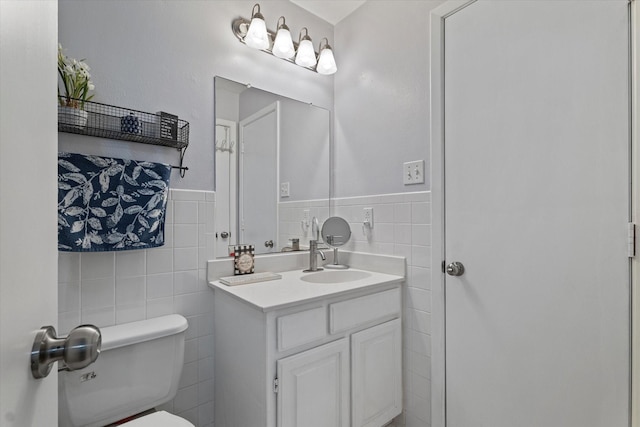 2816 Nottingham Dr, Denton, TX 76209 - half bathroom with tile walls, toilet, vanity, and a wainscoted wall