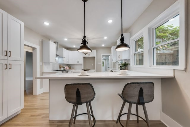 5836 Marquita Ave, Dallas, TX 75206 - kitchen with white cabinetry, light wood finished floors, a peninsula, recessed lighting, and light countertops