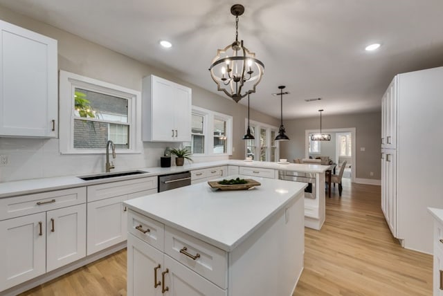 5836 Marquita Ave, Dallas, TX 75206 - kitchen with a sink, a chandelier, a peninsula, light wood-style floors, and recessed lighting