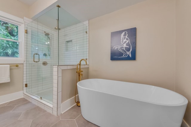 5836 Marquita Ave, Dallas, TX 75206 - bathroom featuring a shower stall, a freestanding bath, tile patterned floors, and baseboards