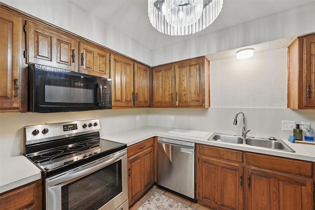 3407 Dovecreek Dr, Arlington, TX 76016 - kitchen featuring appliances with stainless steel finishes, a sink, brown cabinetry, and light countertops