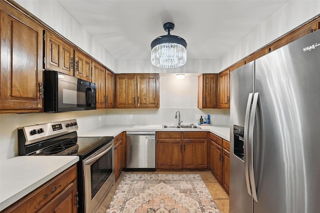 3407 Dovecreek Dr, Arlington, TX 76016 - kitchen with stainless steel appliances, a sink, brown cabinetry, and a chandelier