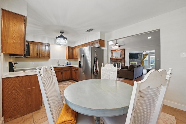 3407 Dovecreek Dr, Arlington, TX 76016 - kitchen with appliances with stainless steel finishes, brown cabinetry, a ceiling fan, a sink, and light countertops