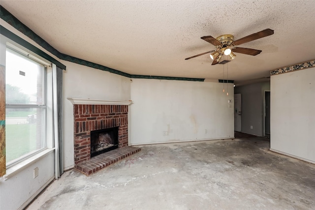 7922 Jubilant Dr, Dallas, TX 75237 - unfurnished living room with unfinished concrete flooring, a textured ceiling, a ceiling fan, healthy amount of natural light, and a brick fireplace