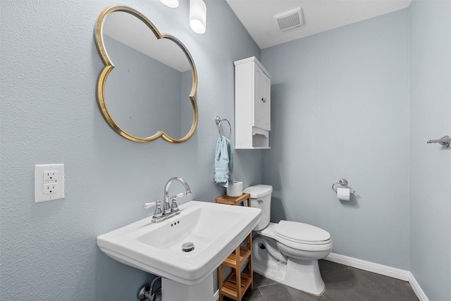 211 N 40th St, Waco, TX 76710 - half bath featuring toilet, tile patterned flooring, a sink, and baseboards