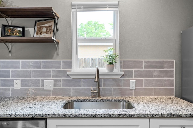 406 N Ruddell St, Denton, TX 76209 - kitchen with a sink, backsplash, white cabinetry, and light stone counters