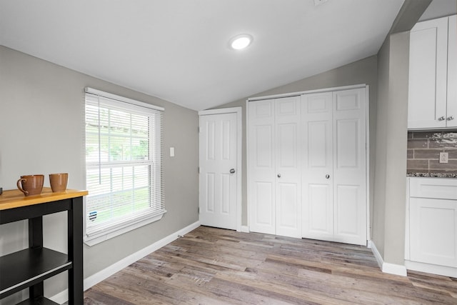 406 N Ruddell St, Denton, TX 76209 - unfurnished bedroom featuring vaulted ceiling, light wood-style flooring, baseboards, and two closets