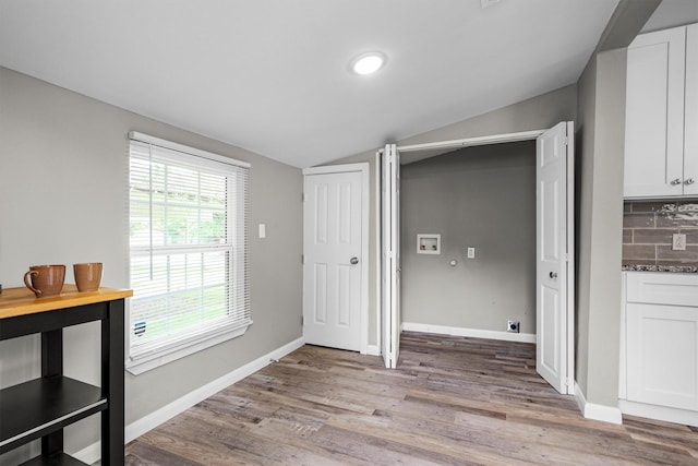 406 N Ruddell St, Denton, TX 76209 - unfurnished dining area with lofted ceiling, light wood-style flooring, and baseboards