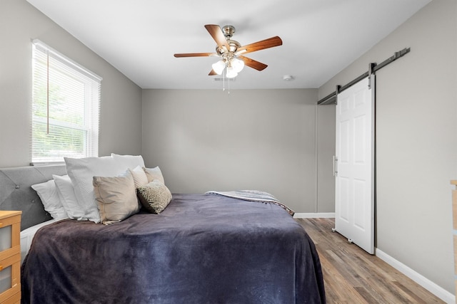 406 N Ruddell St, Denton, TX 76209 - bedroom with wood finished floors, a barn door, baseboards, and ceiling fan
