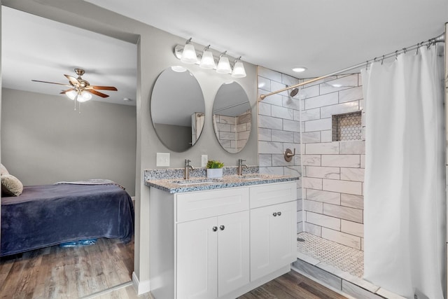 406 N Ruddell St, Denton, TX 76209 - bathroom featuring wood finished floors, double vanity, a tile shower, a ceiling fan, and connected bathroom