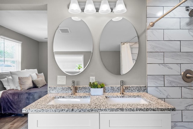 406 N Ruddell St, Denton, TX 76209 - full bathroom featuring double vanity, a shower with shower curtain, and wood finished floors