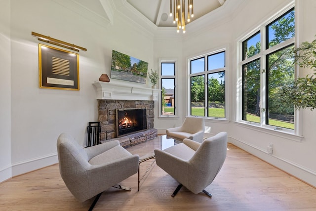 2 Terrabella Ln, Heath, TX 75032 - living area with ornamental molding, baseboards, wood finished floors, a stone fireplace, and a chandelier