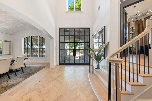 2 Terrabella Ln, Heath, TX 75032 - entryway with a chandelier, stairs, arched walkways, a high ceiling, and baseboards
