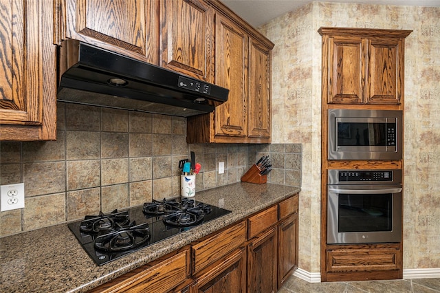437 Fox Trl, Allen, TX 75002 - kitchen with appliances with stainless steel finishes, brown cabinets, under cabinet range hood, and tasteful backsplash