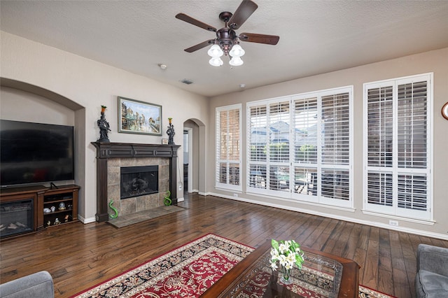 437 Fox Trl, Allen, TX 75002 - living area featuring a tiled fireplace, hardwood / wood-style flooring, a ceiling fan, and baseboards