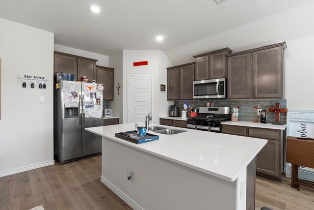 719 Dove Haven Way, Lavon, TX 75166 - kitchen featuring appliances with stainless steel finishes, a sink, dark brown cabinetry, light countertops, and light wood-style flooring