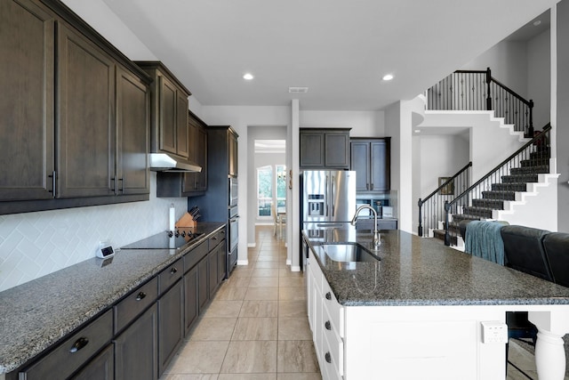 2806 Palmerston Dr, Midlothian, TX 76065 - kitchen with a sink, black electric cooktop, under cabinet range hood, decorative backsplash, and dark brown cabinets