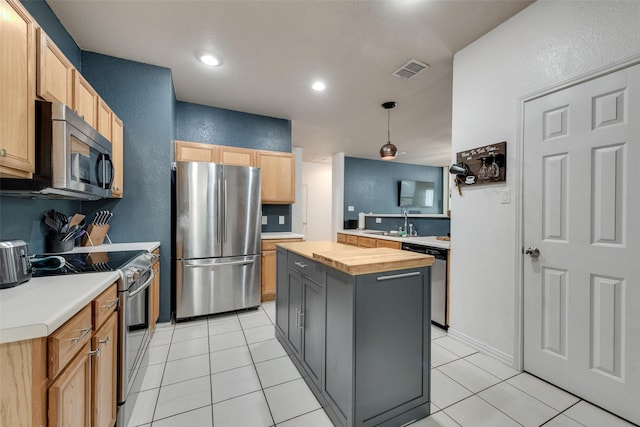 1053 Pullman Dr, Saginaw, TX 76131 - kitchen with stainless steel appliances, wooden counters, a textured wall, a sink, and a kitchen island