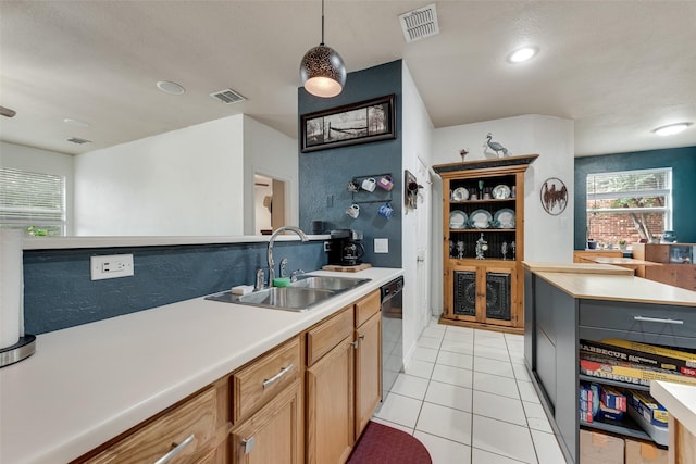 1053 Pullman Dr, Saginaw, TX 76131 - kitchen featuring dishwashing machine, a sink, light countertops, and light tile patterned floors