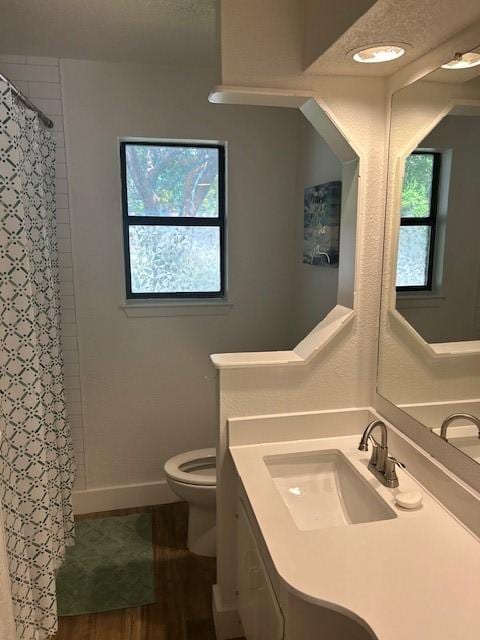 3624 Aurora St, Haltom City, TX 76117 - bathroom featuring toilet, vanity, curtained shower, wood finished floors, and baseboards