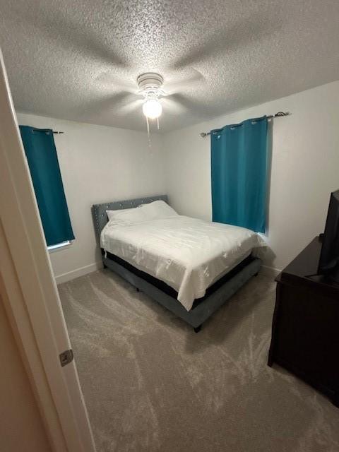 3624 Aurora St, Haltom City, TX 76117 - bedroom featuring a textured ceiling, carpet, ceiling fan, and baseboards