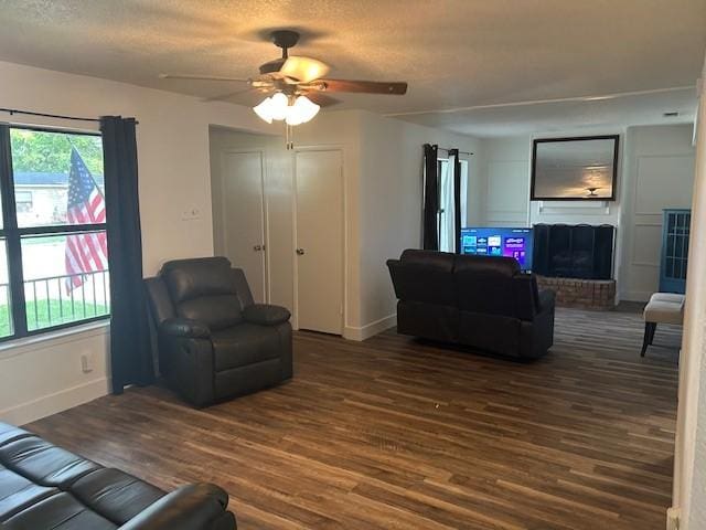 3624 Aurora St, Haltom City, TX 76117 - living area featuring wood finished floors, a fireplace, baseboards, a ceiling fan, and a textured ceiling