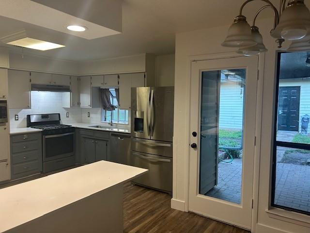 3624 Aurora St, Haltom City, TX 76117 - kitchen featuring stainless steel fridge, range with gas stovetop, gray cabinets, a sink, and under cabinet range hood