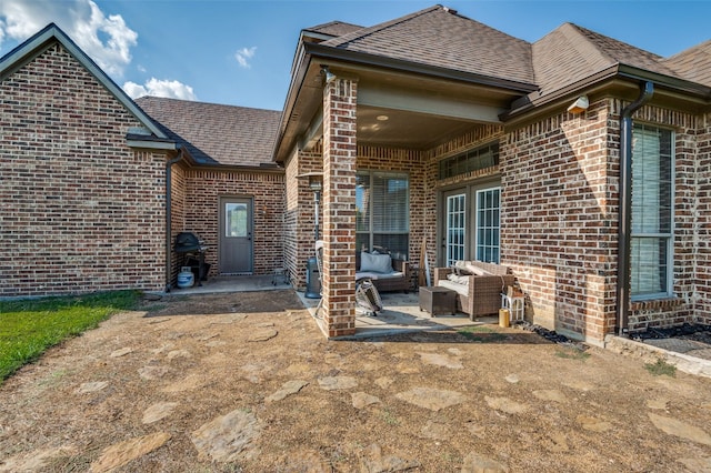 336 Maggie St, Canton, TX 75103 - rear view of house with brick siding, a patio, an outdoor hangout area, and roof with shingles