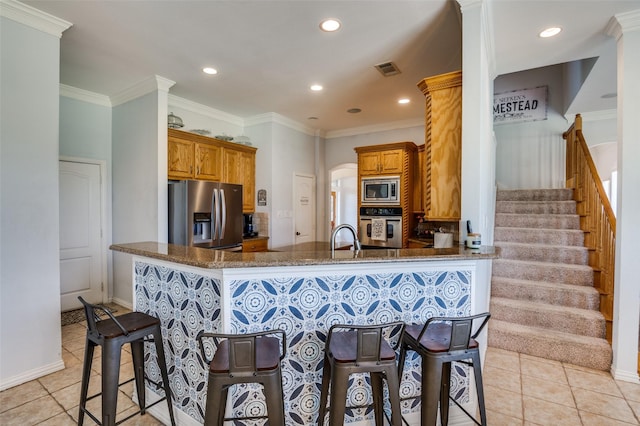 336 Maggie St, Canton, TX 75103 - kitchen featuring appliances with stainless steel finishes, light tile patterned flooring, brown cabinets, dark stone counters, and recessed lighting