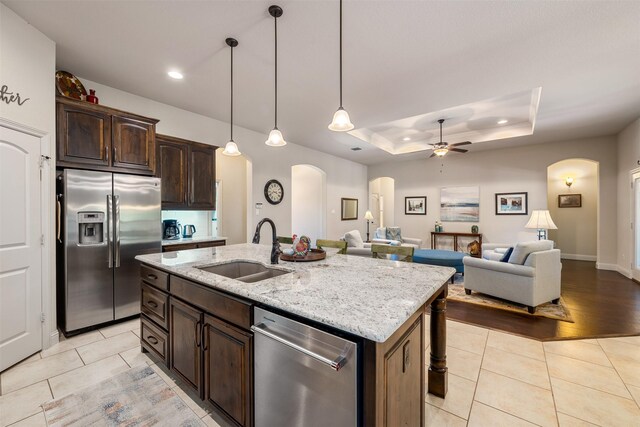 217 Golden Arrow Dr, Weatherford, TX 76087 - kitchen with appliances with stainless steel finishes, a sink, arched walkways, a ceiling fan, and light tile patterned flooring