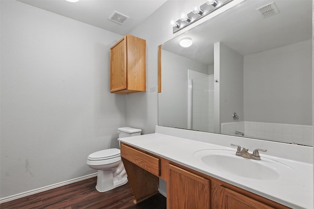 2712 Murphy Dr, Lancaster, TX 75134 - full bathroom featuring wood finished floors, vanity, toilet, a shower, and baseboards