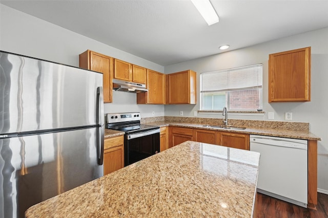 2712 Murphy Dr, Lancaster, TX 75134 - kitchen featuring appliances with stainless steel finishes, a sink, under cabinet range hood, dark wood-style flooring, and brown cabinets