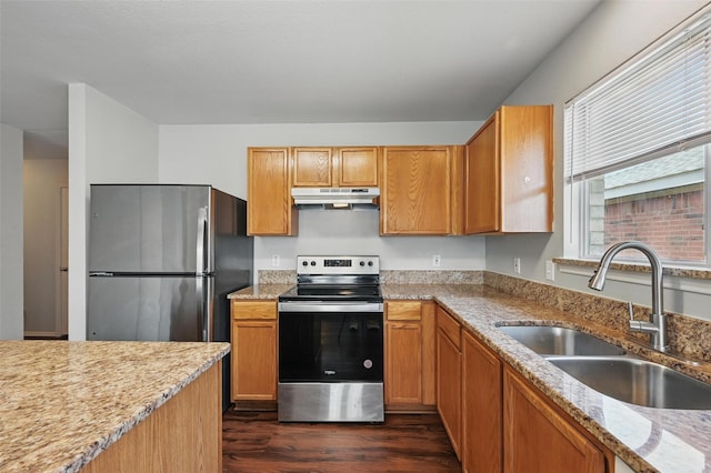 2712 Murphy Dr, Lancaster, TX 75134 - kitchen with appliances with stainless steel finishes, a sink, under cabinet range hood, dark wood-style floors, and light stone counters