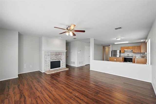 2712 Murphy Dr, Lancaster, TX 75134 - unfurnished living room featuring a sink, dark wood finished floors, ceiling fan, baseboards, and a fireplace