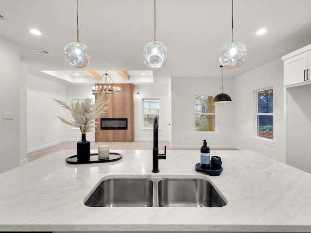 2207 Irion Ave, Fort Worth, TX 76106 - kitchen featuring a sink, recessed lighting, light stone countertops, hanging light fixtures, and white cabinets