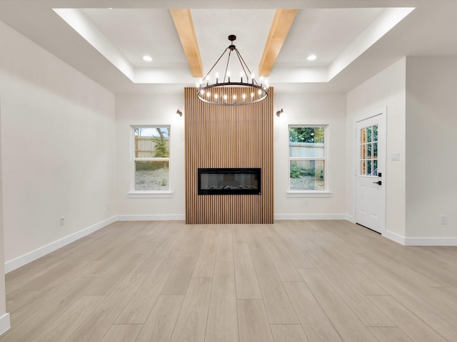 2207 Irion Ave, Fort Worth, TX 76106 - unfurnished living room with a chandelier, light wood-style flooring, a raised ceiling, healthy amount of natural light, and recessed lighting