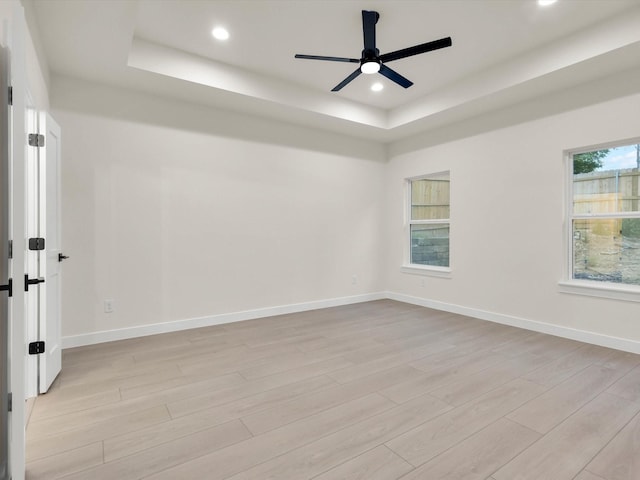 2207 Irion Ave, Fort Worth, TX 76106 - empty room with a tray ceiling, light wood-style flooring, recessed lighting, a ceiling fan, and baseboards