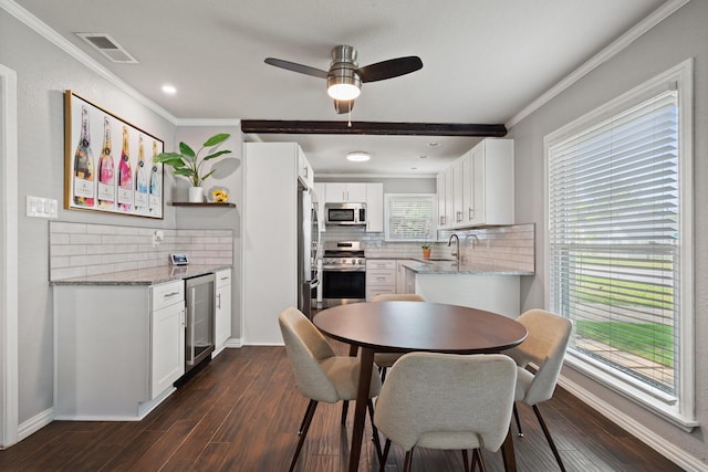 2617 Benbrook Blvd, Fort Worth, TX 76109 - dining room featuring beverage cooler, crown molding, a dry bar, dark wood-type flooring, and a ceiling fan