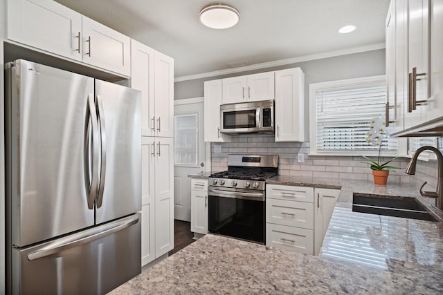 2617 Benbrook Blvd, Fort Worth, TX 76109 - kitchen featuring stainless steel appliances, a sink, ornamental molding, light stone counters, and white cabinetry